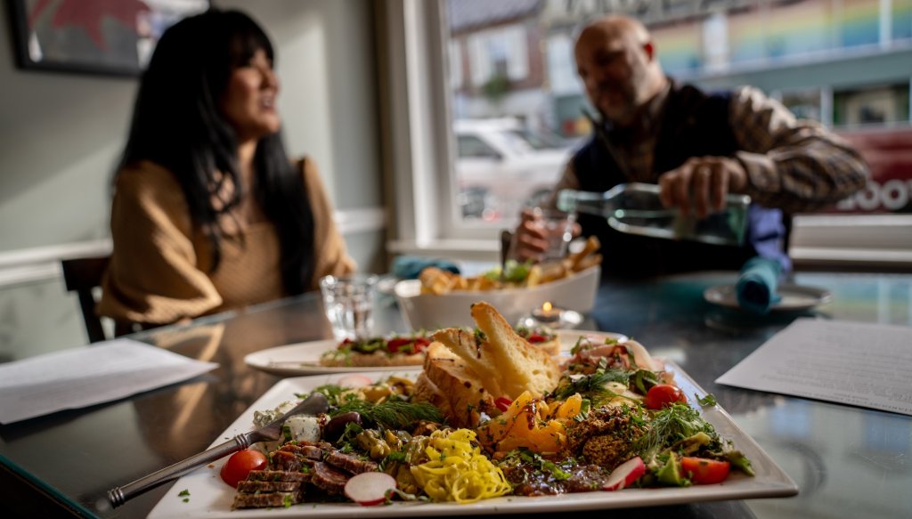 A plate of food with a couple in the background enjoying their meal.