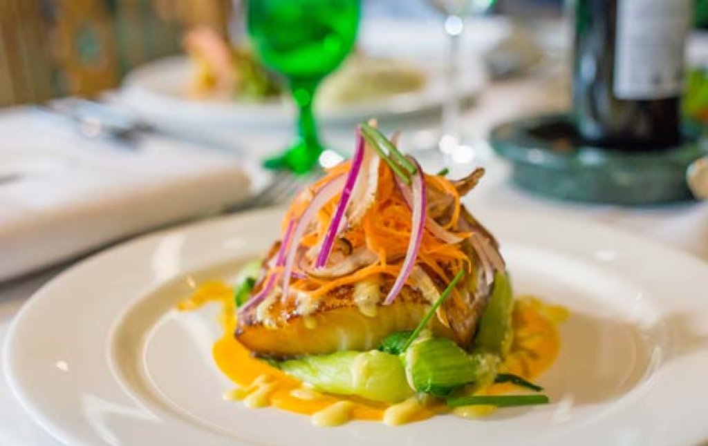 A plate of Greenbrier Resort sea bass elegantly presented on a table, showcasing a delicious meal.
