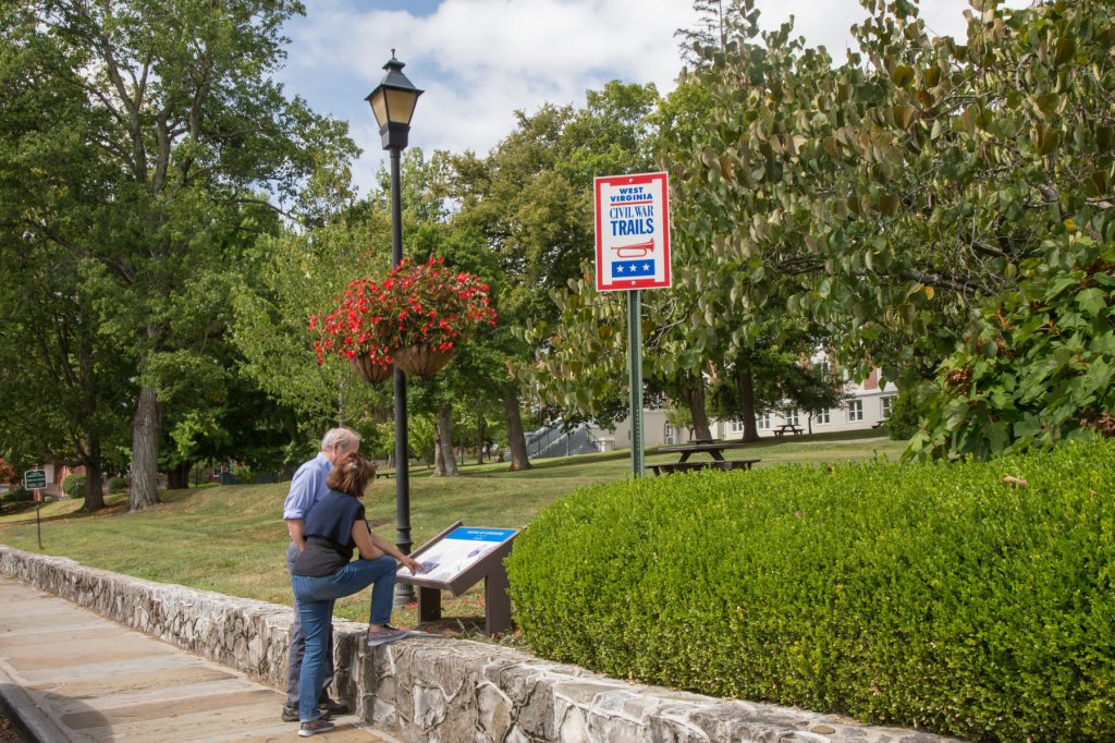 A couple reading an interpretive sign along the West Virginia Civil War Trails in Greenbrier County, one of many free historic sites to explore in the Greenbrier Valley.